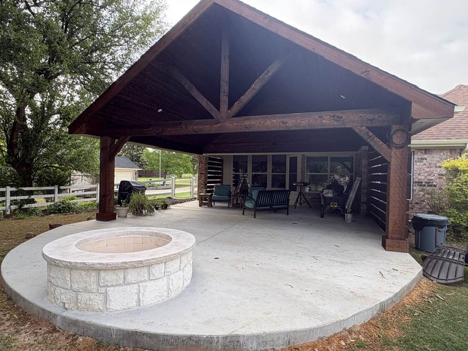 Stained gable pavilion with stone fire pit and rounded concrete patio
